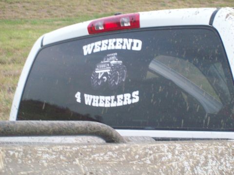 1989 Ford Bronco - A sticker on the rear window of a dirty truck advertises "Weekend 4 Wheelers" with a monster truck graphic.