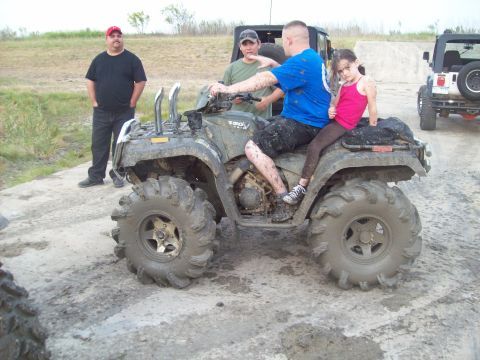 1989 Ford Bronco - People ride a muddy ATV while two Jeeps are visible in the background.