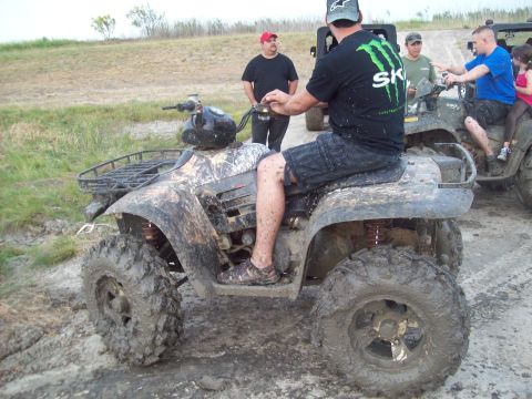 1989 Ford Bronco - Multiple ATVs covered in mud are being ridden in an outdoor, muddy terrain.