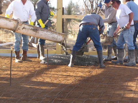1995 Ford Bronco - Workers pour concrete for a new foundation, with a cement truck chute in the foreground.