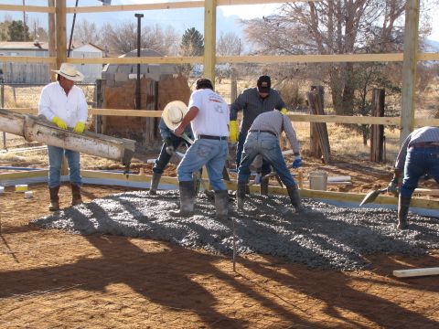 1995 Ford Bronco - Workers pour concrete for a new building's foundation, with a concrete truck chute visible.