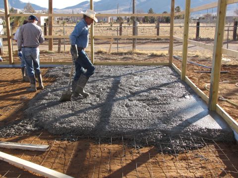 1995 Ford Bronco - Construction workers are pouring and leveling a concrete foundation for a new structure.