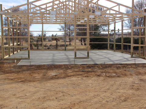 1995 Ford Bronco - A building is under construction, showing its wooden frame and concrete floor with the surrounding landscape visible through the open sides.