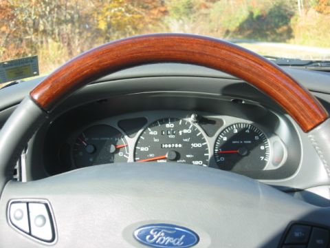 2003 Ford Taurus - The dashboard of a 2003 Ford Taurus, a wood-grain steering wheel and a digital odometer.