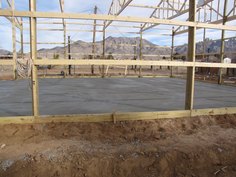 Building frame with concrete floor poured, mountains in background