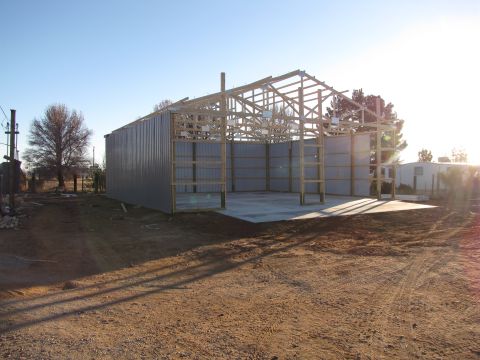 1995 Ford Bronco - A large metal building is in the process of construction, with its frame and partial siding visible.