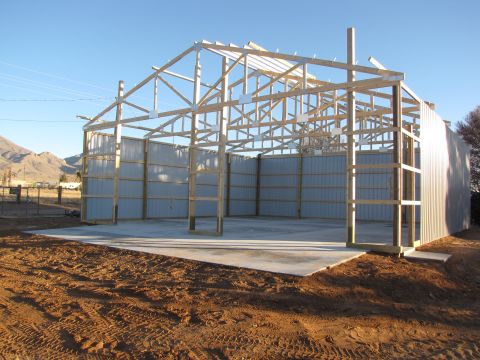1995 Ford Bronco - Construction site shows a metal building in progress, a wooden frame and concrete foundation.