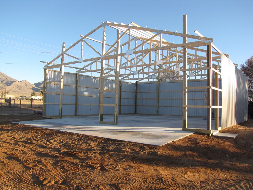 Unfinished metal building under construction with wooden frame and metal siding
