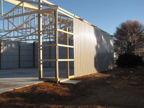 1995 Ford Bronco - Construction site shows an unfinished metal building with exposed wooden framing and a concrete floor.