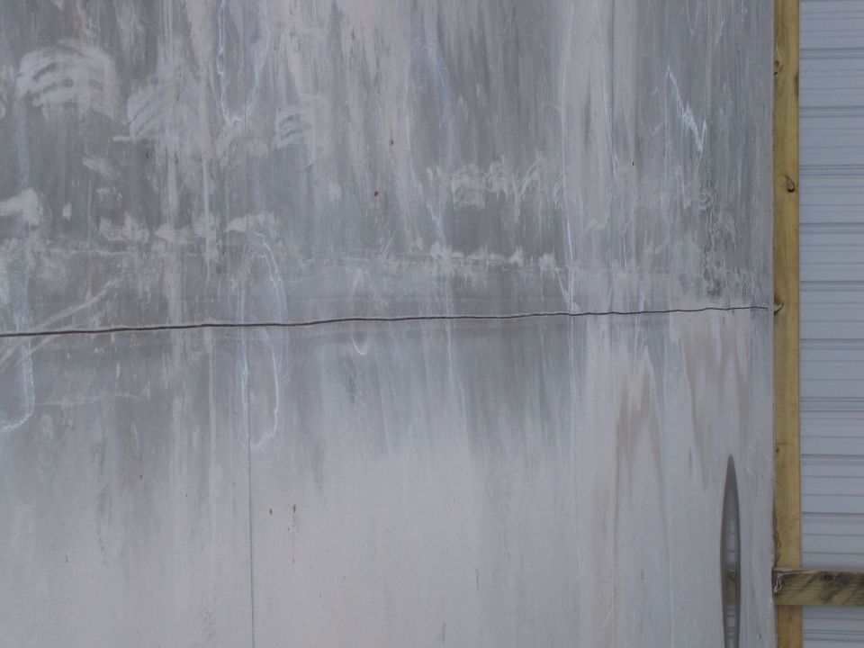Concrete wall with water stains and a Supermotors.net logo in the lower right corner