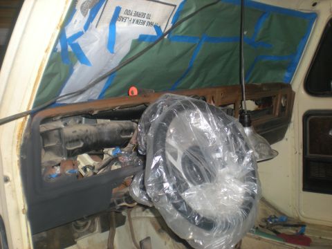 1978 Ford Bronco - Dashboard of a 1978 Ford Bronco being worked on, with the steering wheel covered.