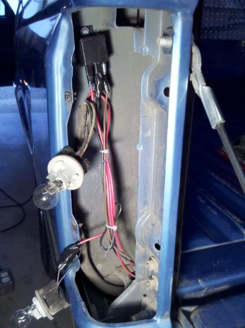 1992 Ford F-150 - Wiring and bulbs are exposed in the tail light housing of a blue vehicle.
