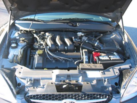 2003 Ford Taurus - Engine bay view of a 2003 Ford Taurus, showing the V6 engine and battery.