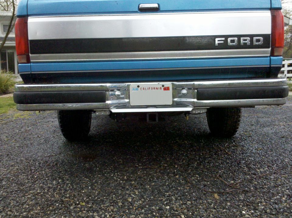 Blue Ford truck rear with chrome bumper and "FORD" tailgate lettering. California license plate visible