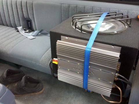 1992 Ford F-150 - Subwoofer and amplifier installed in the rear of a truck, with a seatbelt visible.