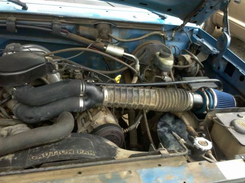 1992 Ford F-150 - The engine bay of a vehicle, an aftermarket air intake system and various engine components.