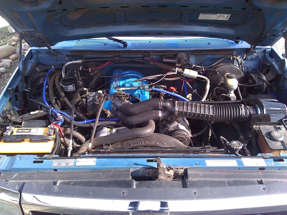 Blue truck engine bay with blue intake manifold and black hoses