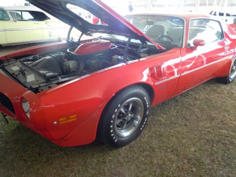 1982 Chevrolet Camaro - A red coupe with its hood open is parked on grass, with another vehicle visible in the background.