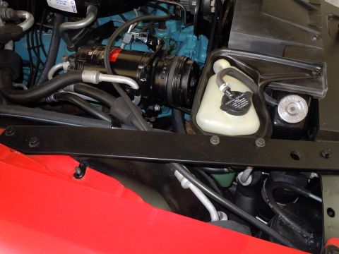 1982 Chevrolet Camaro - Close-up view of engine bay components, including the AC compressor and coolant reservoir.