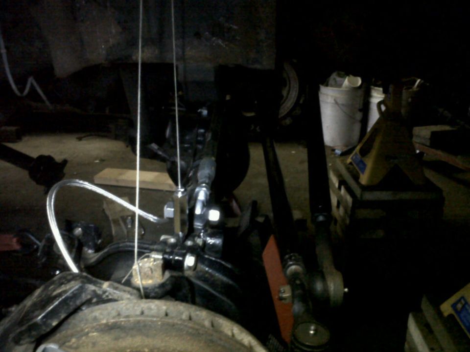 Close-up of a vehicle's suspension and steering linkage, possibly during maintenance