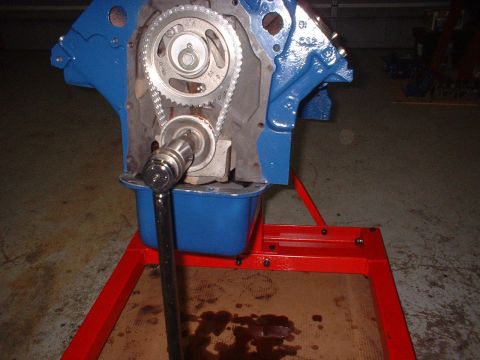 1969 Mercury Cyclone - Engine block assembly with timing chain and gears, on a stand with a wrench.