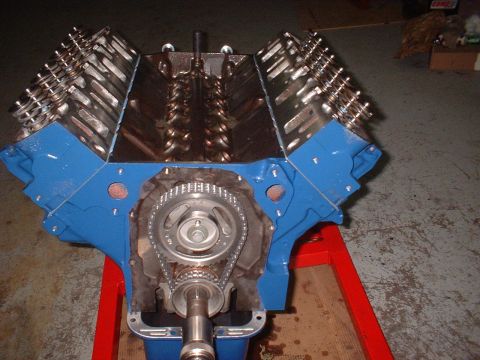 1969 Mercury Cyclone - A blue engine block with a visible timing chain and gears is displayed on a red stand.