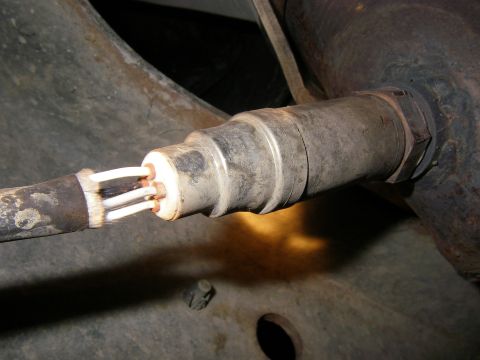 1990 Ford Bronco - Close-up of an oxygen sensor, showing its wiring and connection point.