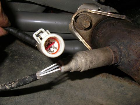 1990 Ford Bronco - Close-up of a disconnected oxygen sensor and exhaust system component.