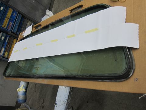 1987 Dodge 1500 - A car window is prepared with paper and tape, likely for a measurement or template.