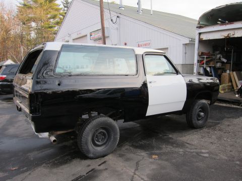 1987 Dodge 1500 - This two-tone SUV, likely a 1987 Dodge 1500, is seen from the side, possibly undergoing repairs or a paint job.