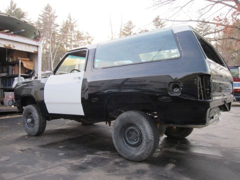 1987 Dodge 1500 - This SUV is undergoing repairs, with one door painted white and the rest black.