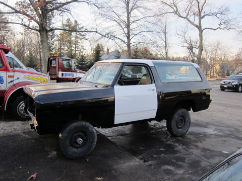 1987 Dodge 1500 - This 1987 Dodge 1500 Ramcharger is undergoing repairs, with its front end disassembled and doors painted white.