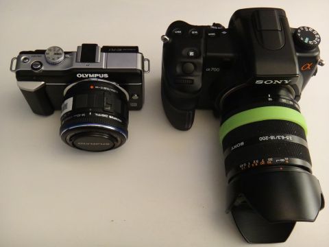 1993 Ford Taurus - Two digital cameras, an Olympus and a Sony Alpha 700, are placed side-by-side on a white surface.