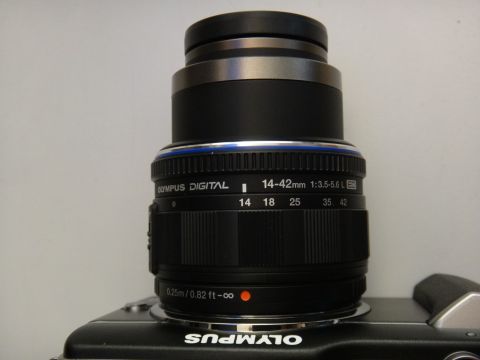1993 Ford Taurus - Close-up of an Olympus digital camera lens, showing the 14-42mm zoom range and aperture details.