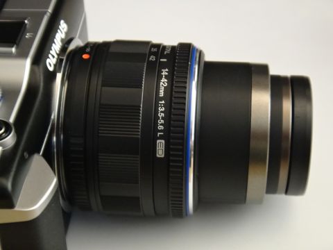 1993 Ford Taurus - Close-up of an Olympus camera body and its attached zoom lens, showing brand and lens specifications.