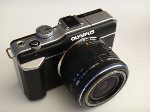 1993 Ford Taurus - An Olympus digital camera with a zoom lens is shown from a 3/4 front perspective against a white background.