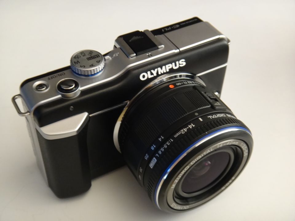Olympus digital camera with lens attached, 3/4 front view
