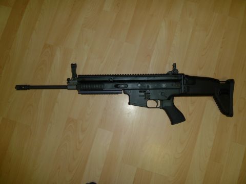 1992 Ford Mustang - A black rifle is shown lying on a wooden floor.