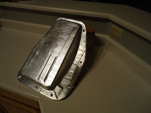 1987 Ford F-150 - A metal heat shield, likely for a vehicle's undercarriage, is shown on a countertop. The registry claims it is from a 1987 Ford F-150, but…