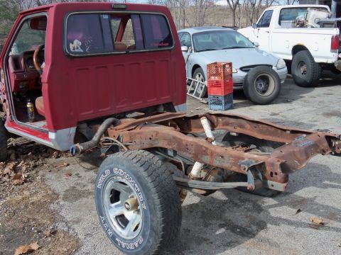 1987 Ford Ranger - The frame and cab of a 1987 Ford Ranger are visible, with significant rust on the chassis.
