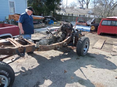 1987 Ford Ranger - The chassis and engine of a 1987 Ford Ranger are visible, with other vehicle parts in the background.