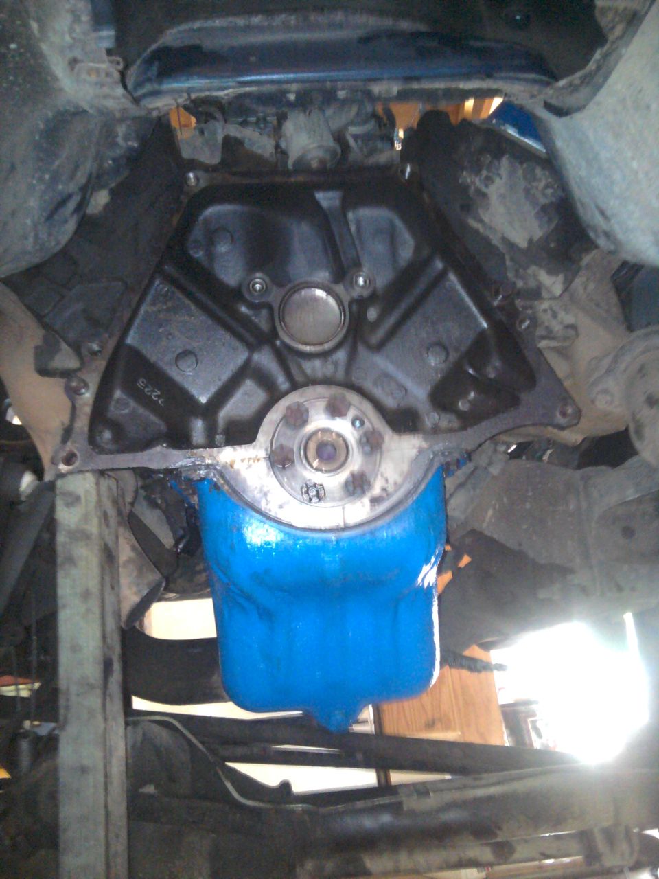 Underside of 1978 Ford Bronco showing rear of engine block, exposed crank flange, and blue-painted oil pan