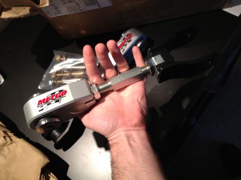 1992 Ford Crown Victoria - A person holds a Metco control arm, a part for a vehicle's suspension system.