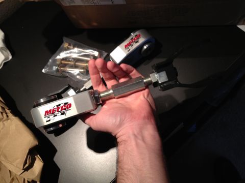 1992 Ford Crown Victoria - A hand holds a Metco adjustable control arm, with a bag of hardware and another control arm visible.