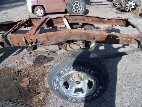 1987 Ford Ranger - This is a heavily rusted truck frame, not a complete vehicle. A tire is attached.