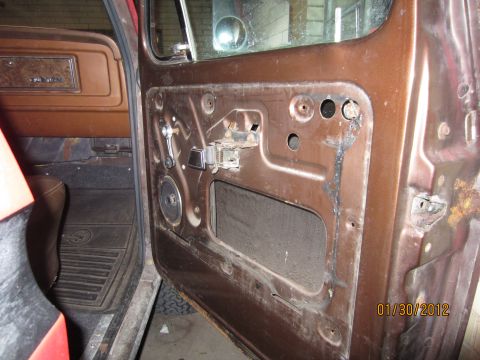 1979 Ford Bronco - The interior door panel of a 1979 Ford Bronco shows exposed metal and a window crank mechanism.