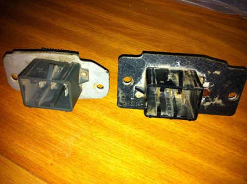 1998 Ford Crown Victoria - Two blower motor resistors are shown side-by-side on a wooden surface. One appears to be a replacement part.