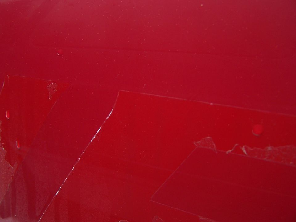 Red painted surface with tape residue visible