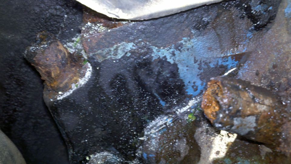 Close-up of corroded engine block with blue and white residue