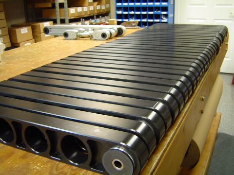 2004 Ford Crown Victoria - A close-up view of a black metal component with a slatted surface, resting on a wooden table.